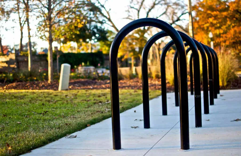 Black U-shaped cycle racks mounted on the ground.