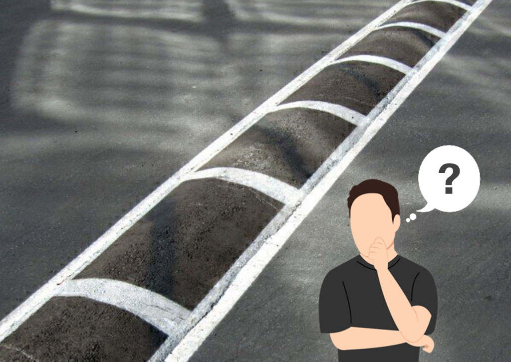 An asphalt speed bump with white markings.