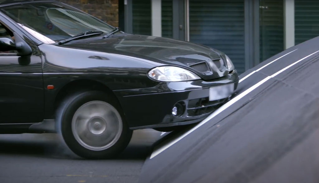 A black car is going up a slope.