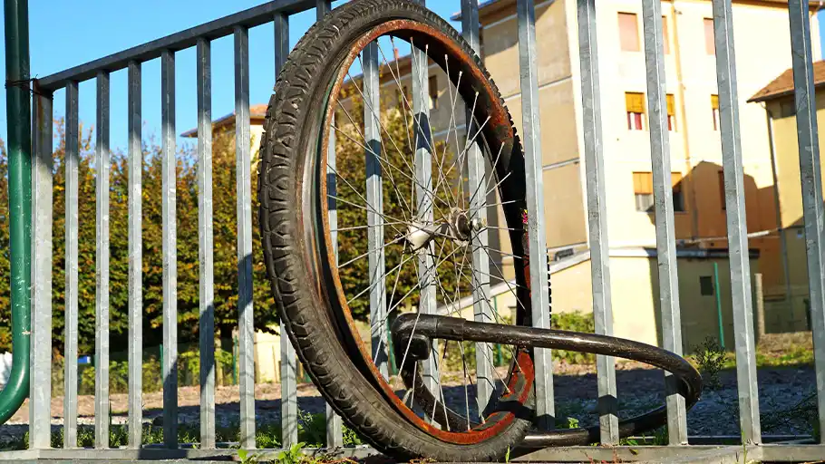 A black lock secures one of the bicycle wheels to a railing.
