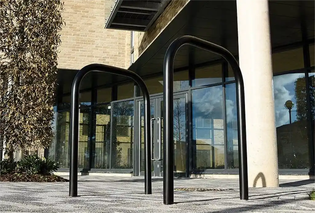 Two black Sheffield-style bicycle racks provide secure parking and storage for bicycles in public areas.