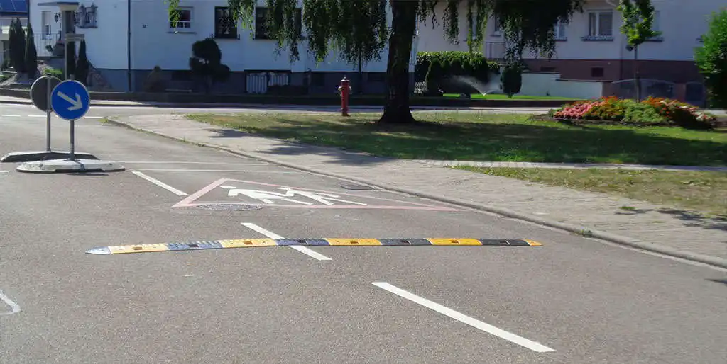 A black and yellow road bump for traffic-calming purposes.