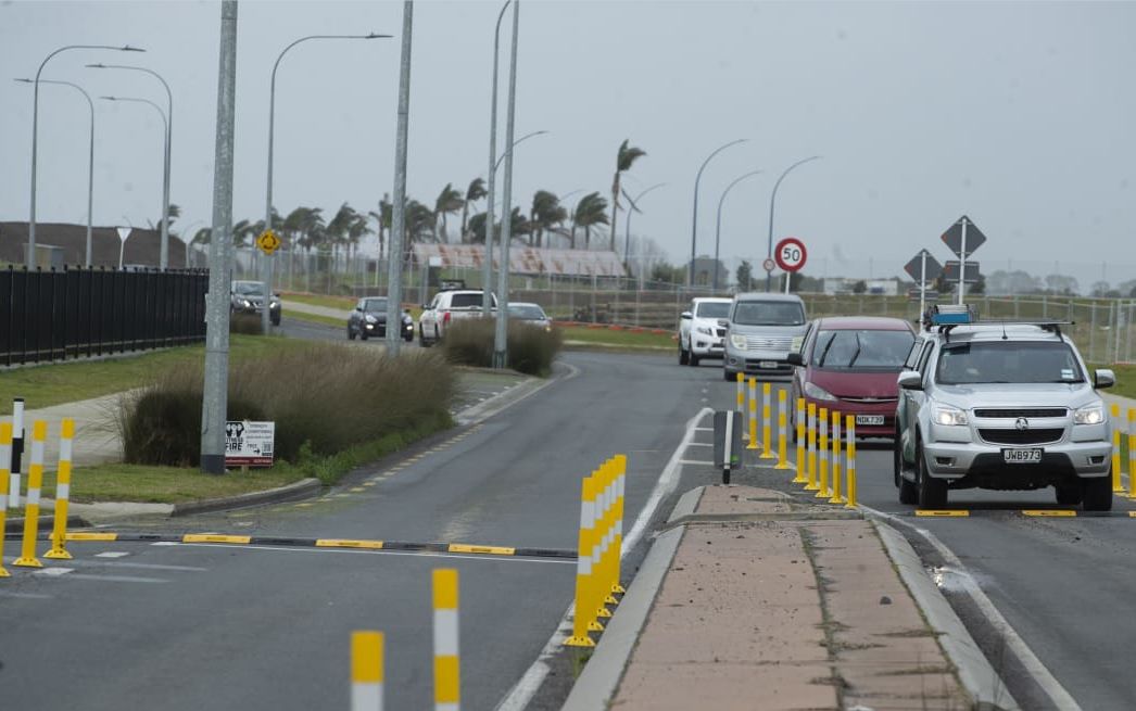 A pair of black and yellow speed bumps on the road as traffic-calming measures.