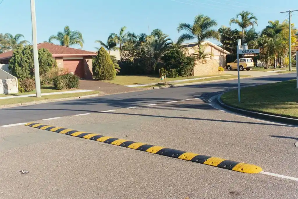 A black and yellow speed ramp on the road for traffic-calming purposes.