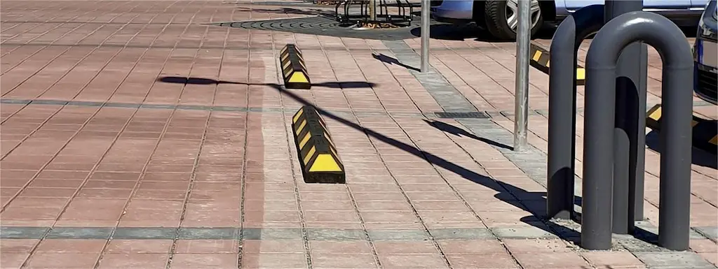 Black and yellow wheel stops used to stop vehicles when parking.
