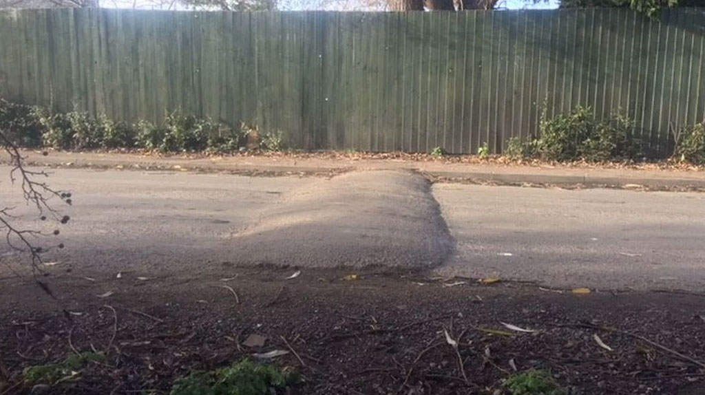 A concrete speed bump on the road for reducing vehicles' speed.