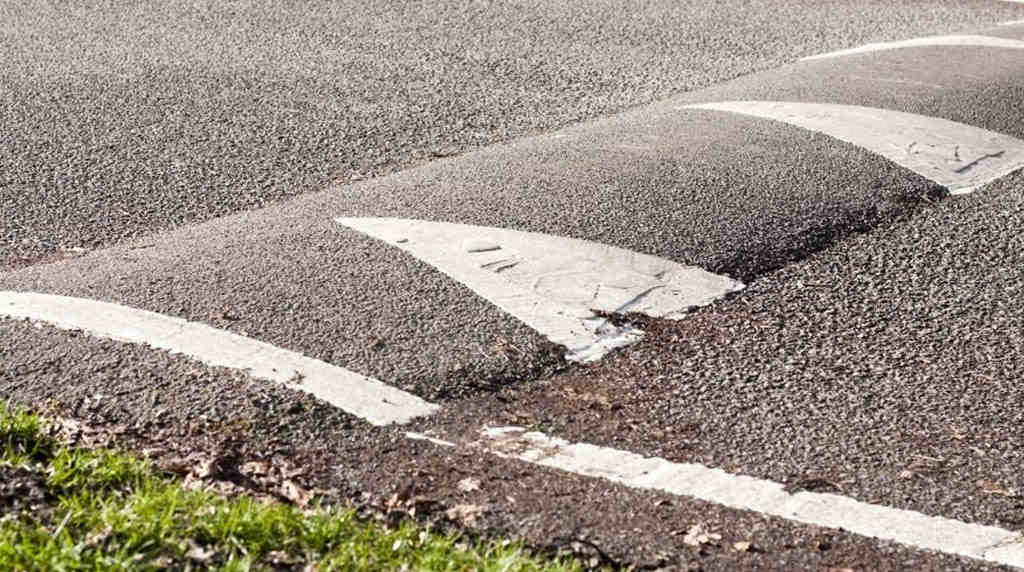 A concrete speed bump with white markings.