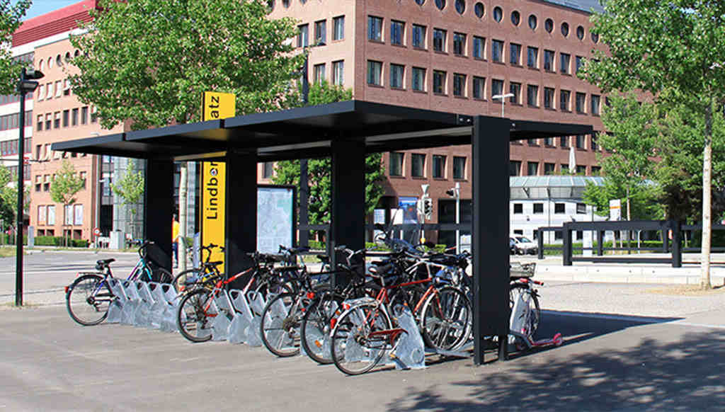 Many bike racks are under the canopy, with plenty of bikes parked.