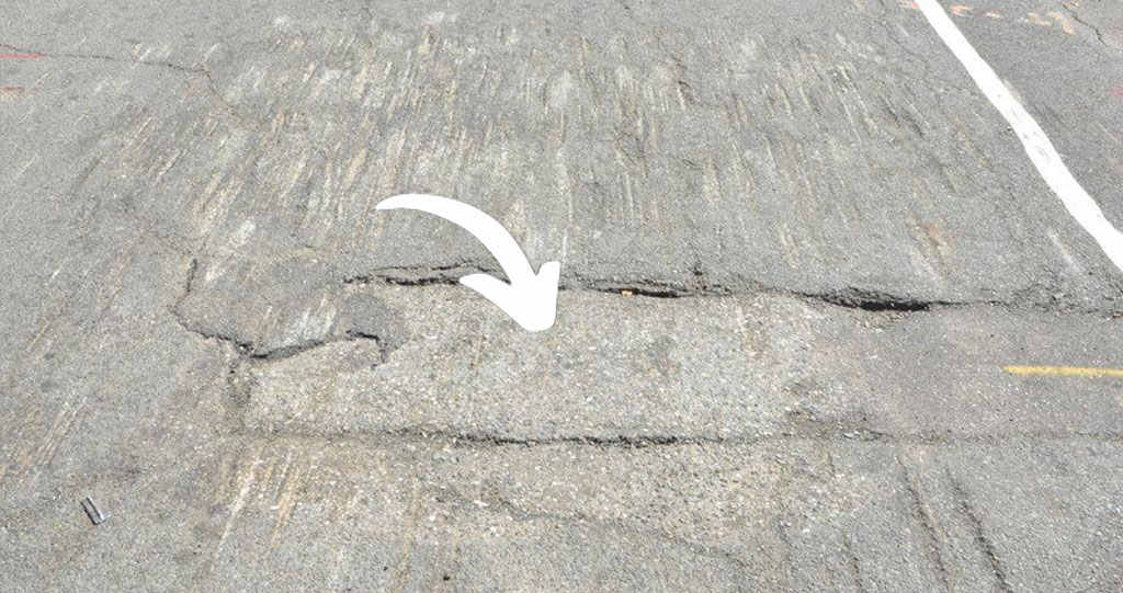 A damaged concrete speed bump.