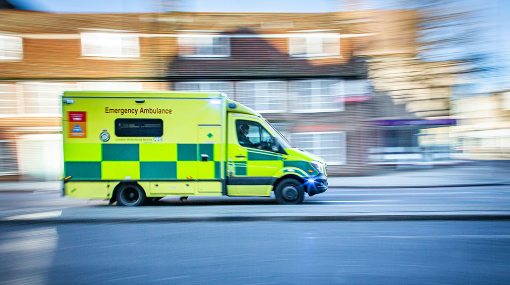 An emergency ambulance is speeding down the road.