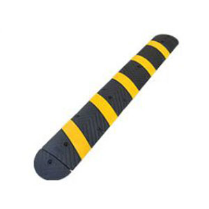 Rubber speed bump of 1830 type made of yellow and black vulcanized rubber used in a parking lot for traffic calming purposes.