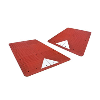 Red UK-type speed tables made of vulcanized recycled rubber and white glass bead reflective tapes used for traffic calming purposes.