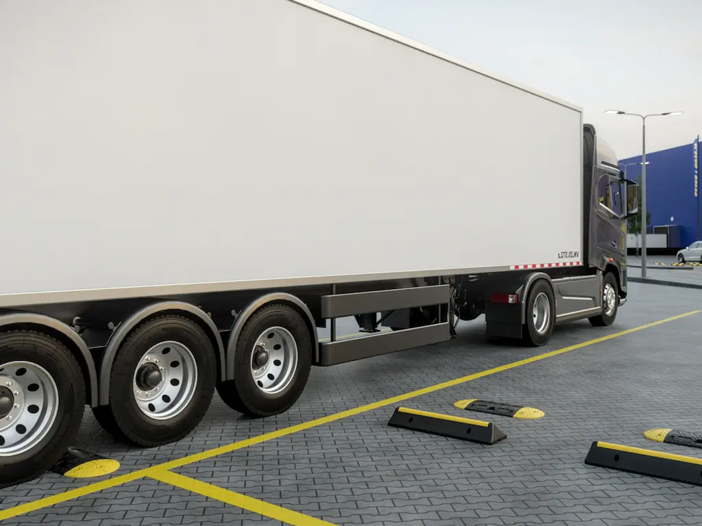 Black and yellow heavy-duty wheel stops and speed bumps used to help trucks park.