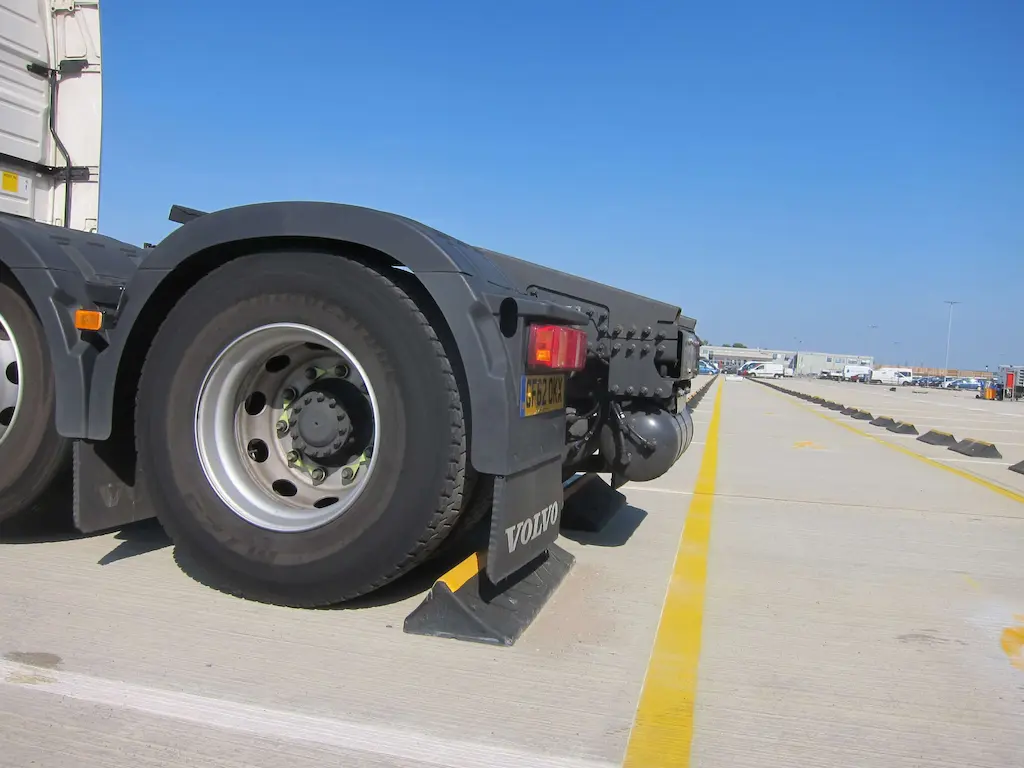 Black and yellow HGV wheel stops used to help heavy-duty vehicles park.