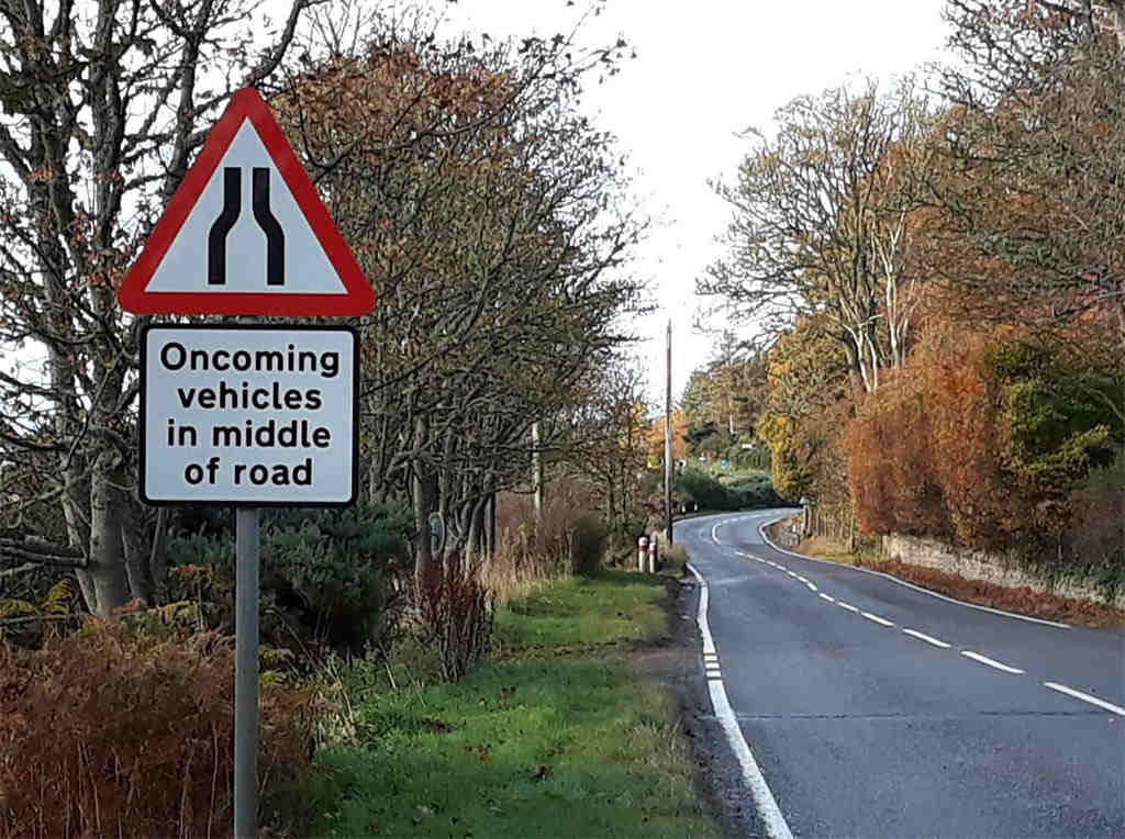 A narrowing road traffic sign.