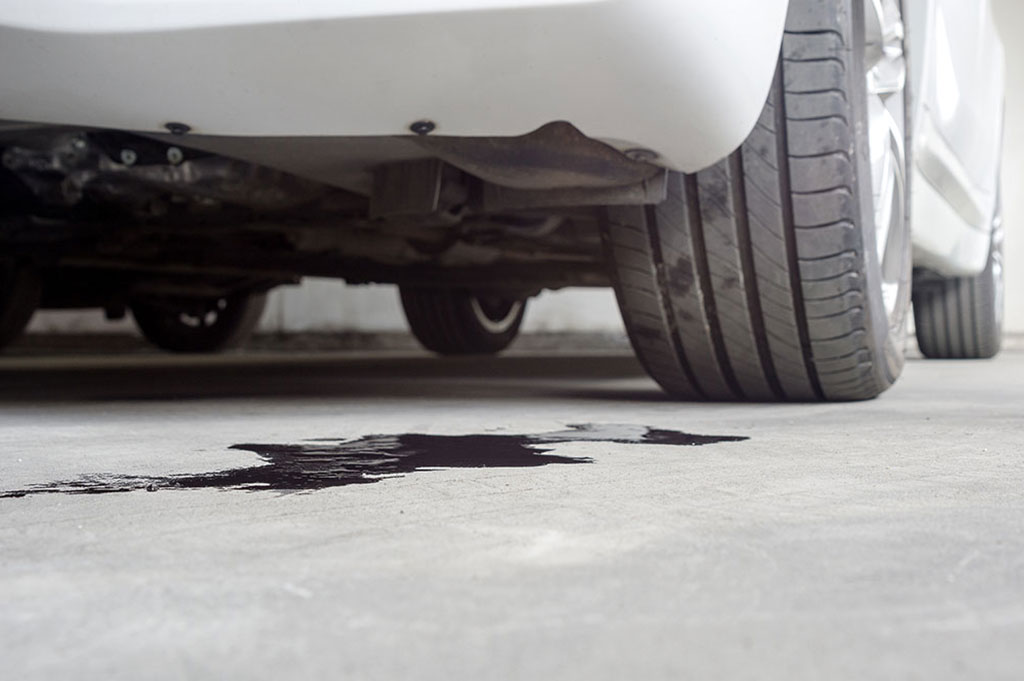 A white car is leaking oil.