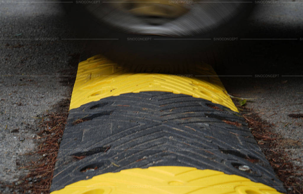A black and yellow plastic-rubber composite road bump to reduce speed.