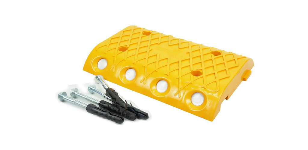 A part of yellow plastic speed bump, and lag bolts with black anchors.