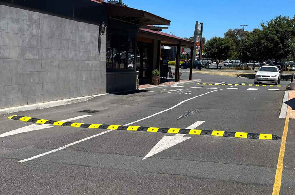 Black and yellow speed bumps made of plastic for traffic-calming purposes.