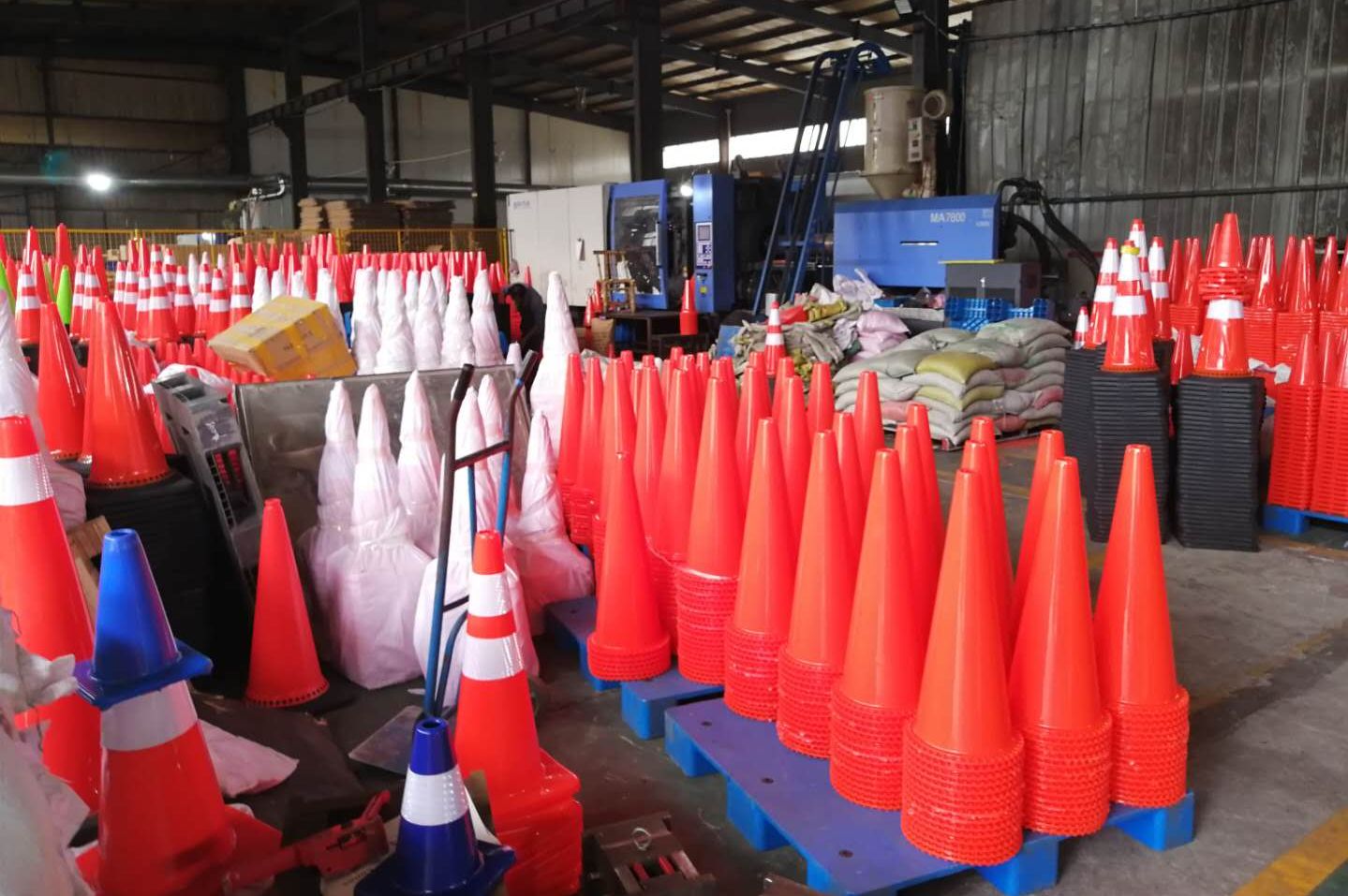 Orange traffic cones made of PVC material with white reflective films in Sino Concept's plastic factory.