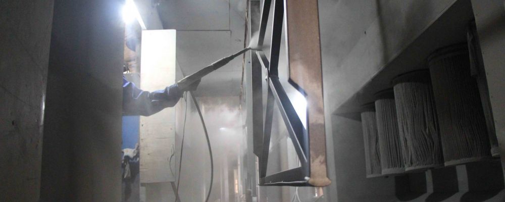 A worker is doing the powder-coating process for cross barriers in Sino Concept's steel factory.