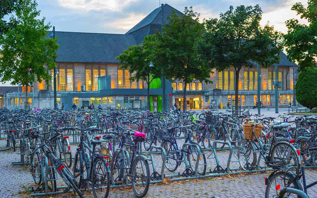 A bike parking lot where many bikes are neatly arranged with the help of rail-mount bike racks.