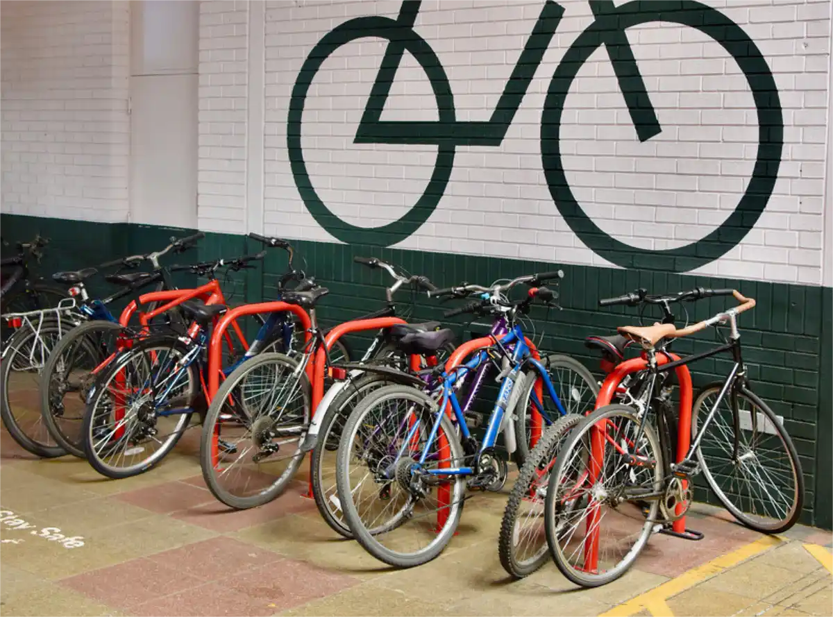 Some red Sheffield-style bike racks with bicycles parked on them.
