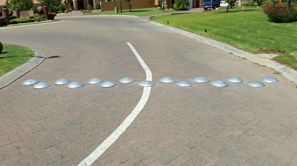 Some round speed bumps made of metal on the road.