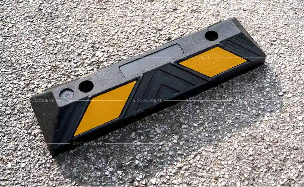 A black rubber parking block with yellow reflective films used for parking management.