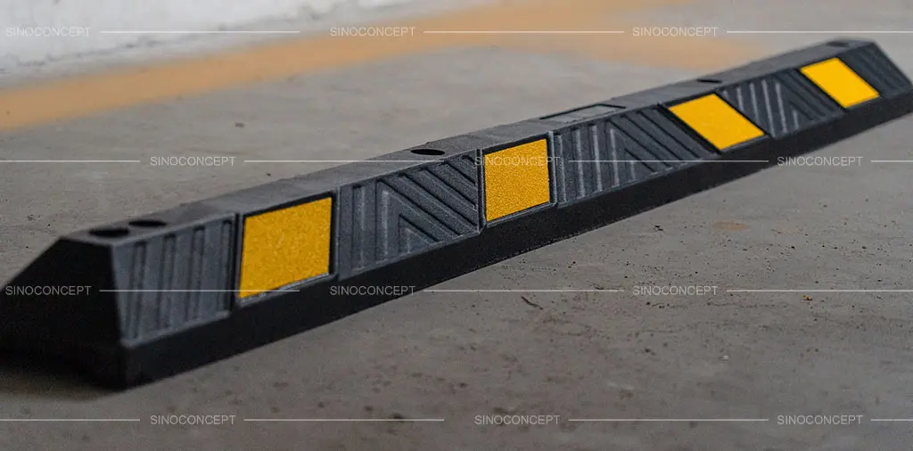 A black parking kerb made of vulcanised rubber with yellow reflective films.
