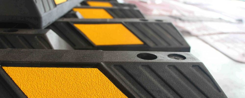 Rubber parking stops are coloured in black and pasted with yellow reflective films to stop vehicles in parking spaces.