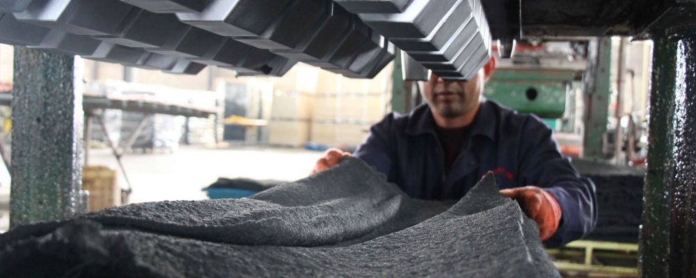 A worker is putting rubber material in the mould for the processing of rubber products in Sino Concept's factory.