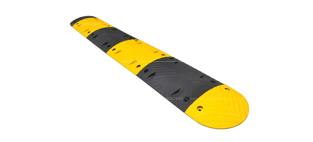 A black and yellow speed bump made of vulcanised rubber.