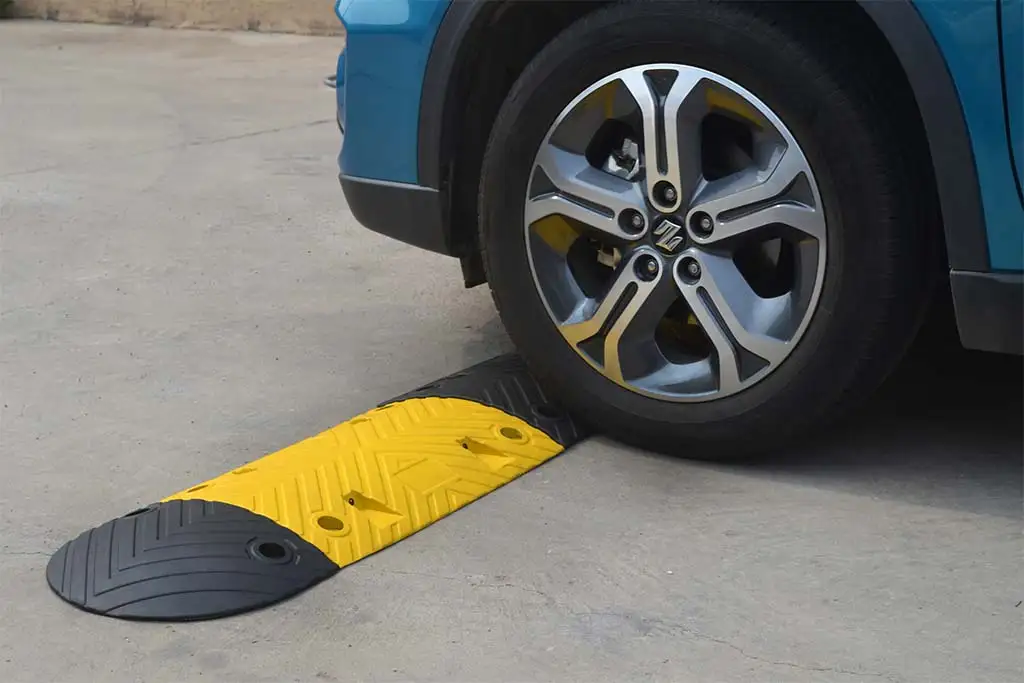A black and yellow speed bump made of vulcanised rubber used for traffic-calming purposes.