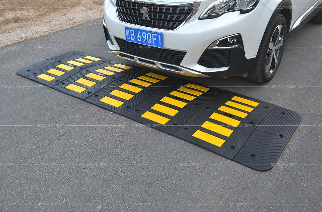 A black rubber speed hump with yellow reflective films.