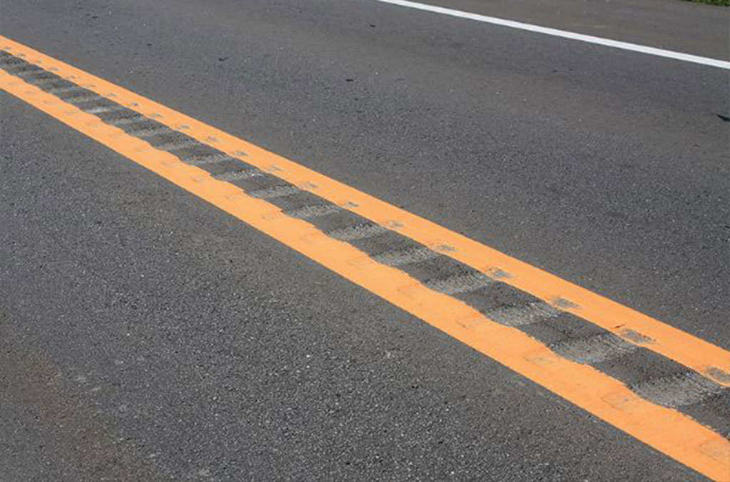 Rumble strips on the road to alert drivers when they move from their traffic lane.