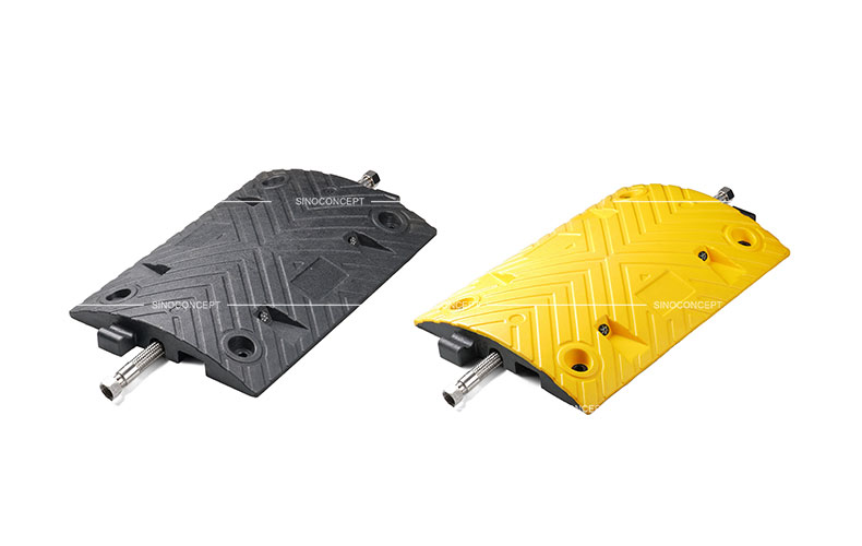 A black and a yellow middle parts of a 5cm high Plastic-Rubber composite speed bump designed with a channel to receive one cable.
