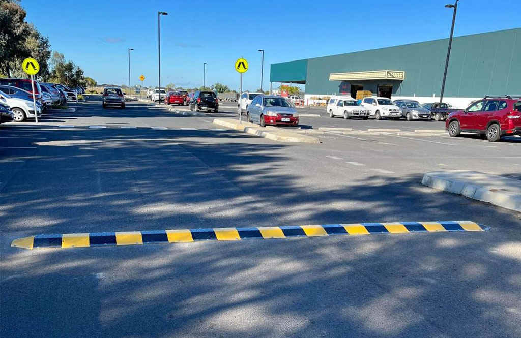 A black and yellow speed bump on the road.