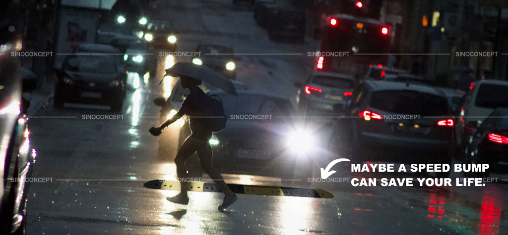 A black and yellow speed bump at night to improve pedestrians' safety.