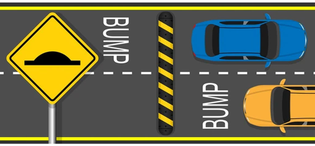 A black and yellow speed bump and a yellow speed bump traffic sign.