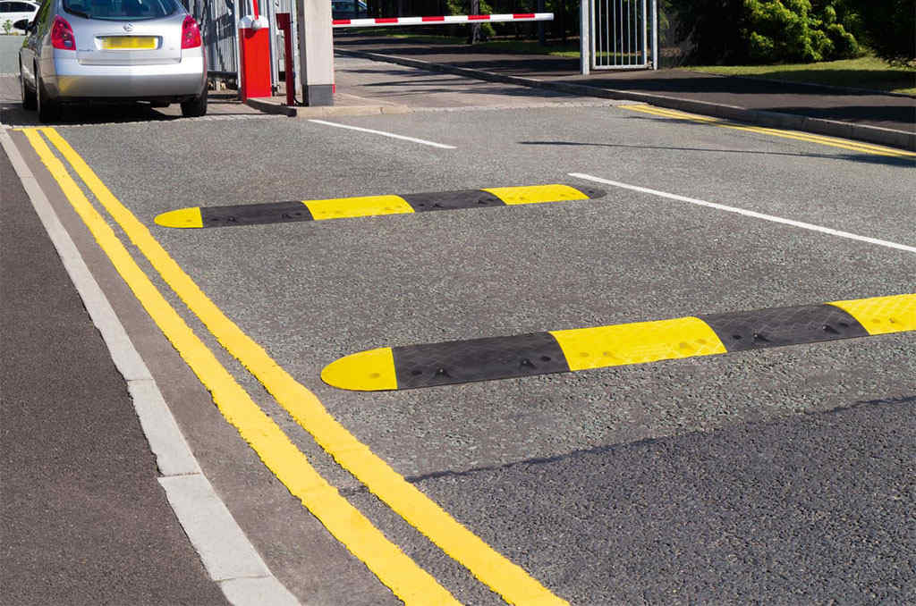 Black and yellow speed bumps on the road to manage traffic.