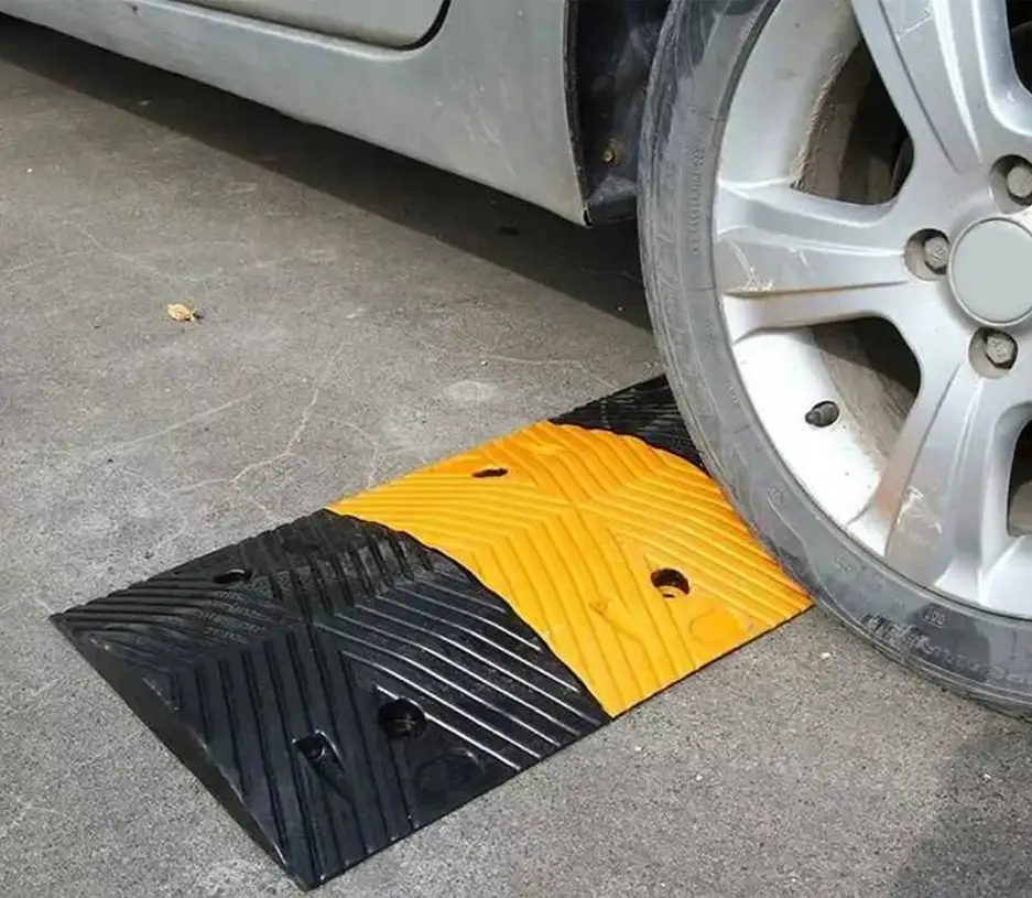 A black and yellow speed ramp on the road to reduce speed.