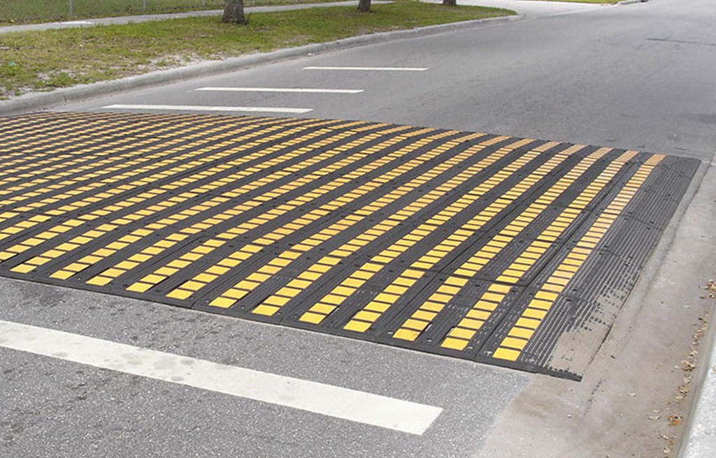 A black and yellow speed table used for traffic-calming purposes.