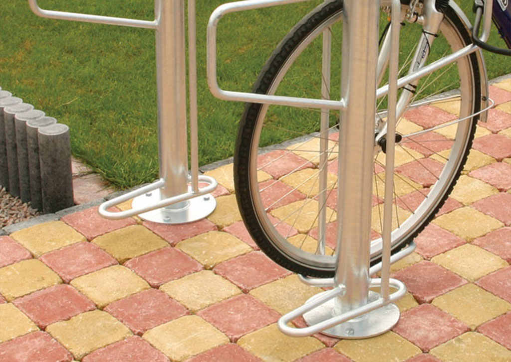Steel cycle racks mounted on the ground with bolts.
