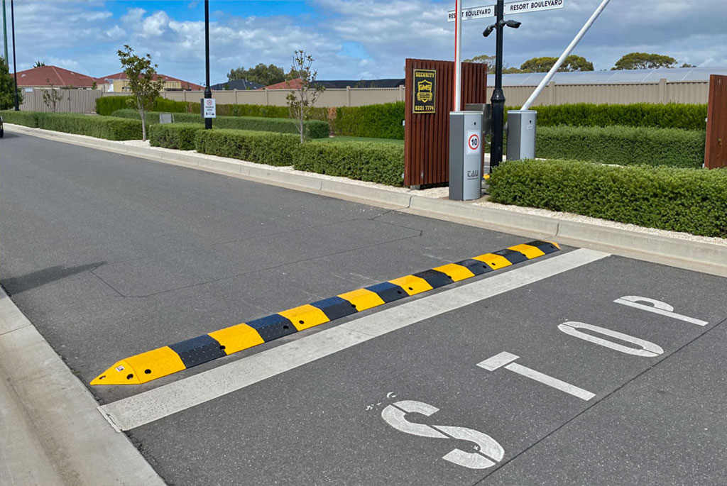 A black and yellow speed bump made of steel.