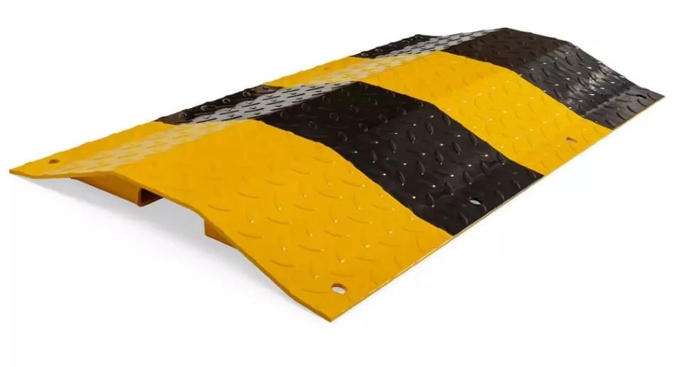 A black and yellow heavy-duty steel speed hump