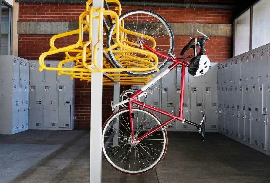 Yellow wall-mounted cycle racks with a red bike hanging on.